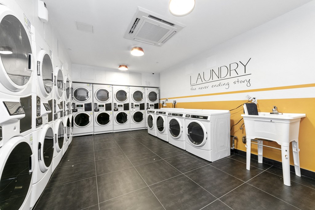 a washer and dryer room with a bunch of washing machines and a table